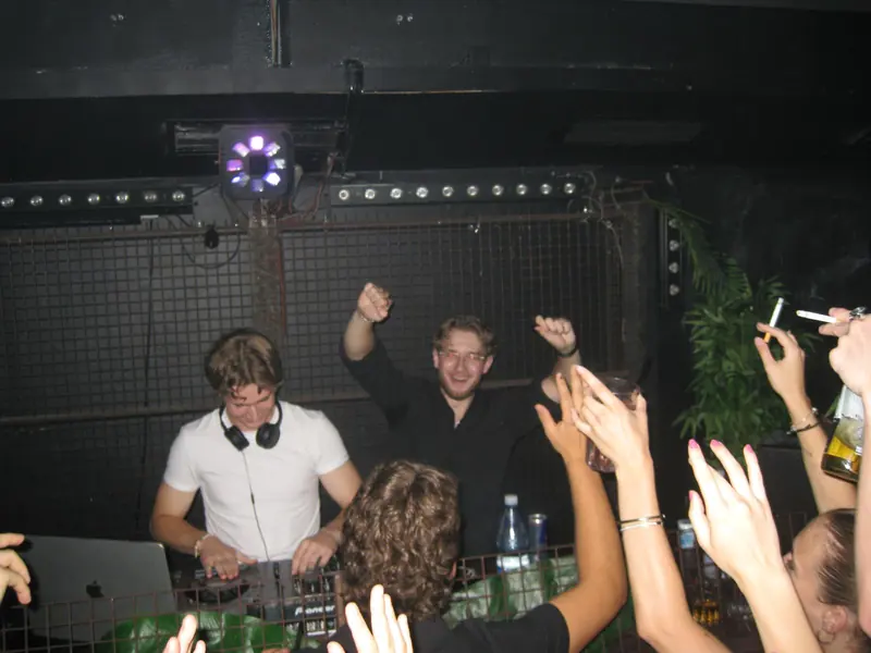 Feiernde Gäste am DJ-Pult