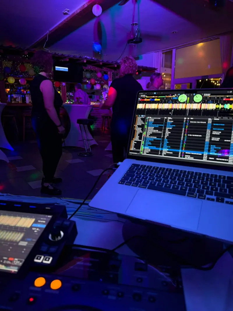 Clubabend mit DJ-Setup im Vordergrund